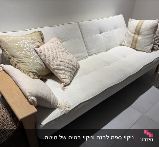 ספה לבנה עם כריות דקורטיביות בחדר מואר